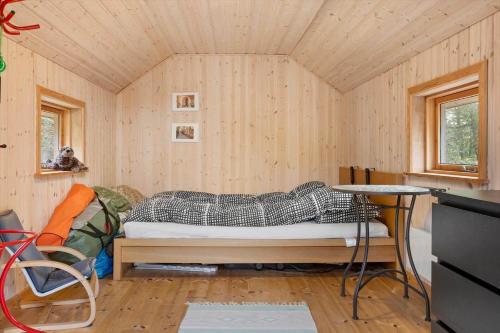 a bedroom with a bed in a room with wooden walls at LF18112-Veslos-Jegindovej-12 in Vesløs