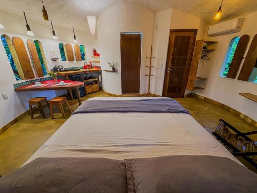 a large bed in a room with a kitchen at Torre Cajila Morro de São Paulo in Cairu