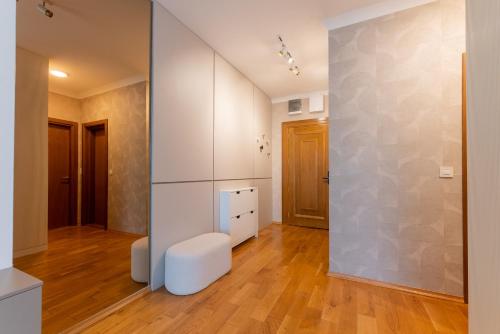 a living room with white walls and a white stool at Apartman Maxim in Palić