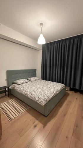 a bedroom with a bed and a black curtain at Warm Apartment 1 in Bucharest