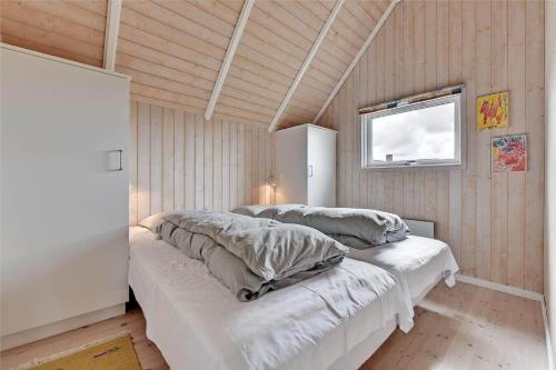 a room with three beds with pillows and a window at BV102-Blavand-Nordslugen-6 in Blåvand