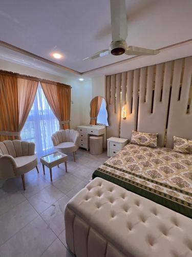 a bedroom with a bed and a couch and a chair at apartment for rent in Islamabad