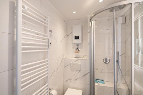 a white bathroom with a shower and a toilet at Studio Relax in Büsum