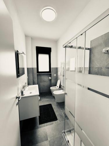 a bathroom with a toilet and a sink and a mirror at NUVOLA Hosting in Segrate