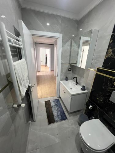 a bathroom with a white toilet and a sink at Bediroğlu Airport Apart in Arnavutköy