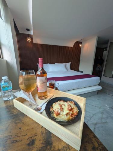 a table with a plate of food and a bottle of wine at Hotel Olimpica Boutique in Mexico City