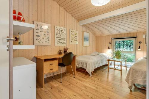 a bedroom with a desk and a bed and a table at BV406-Blavand-Tvaervaenget-2 in Blåvand