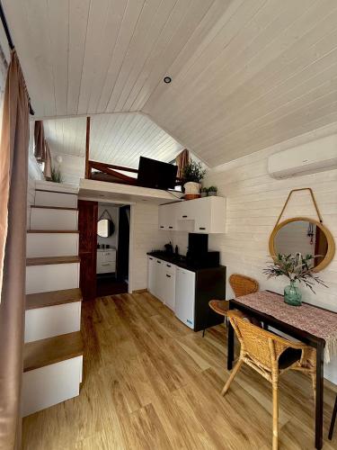 a room with a table and a staircase in a house at Domek w górach Tiny House Forest Jacuzzi/widoki in Lipnica Wielka