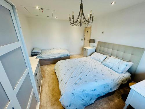 a bedroom with two beds and a chandelier at Bright 3 bed House,FREE parking,Garden,nr seafront in Brighton & Hove