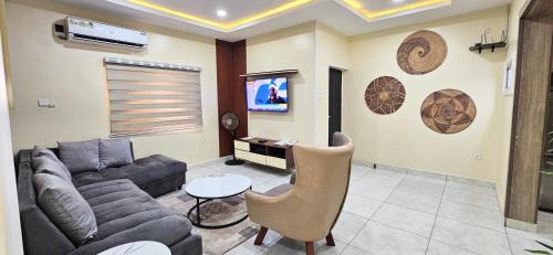 a living room with a couch and a tv at The Leneade - City Centre in Abuja