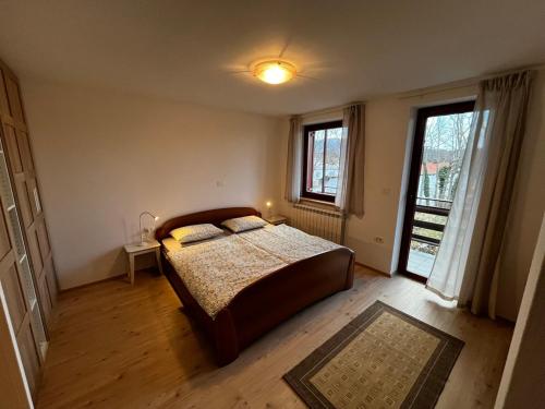 a bedroom with a bed and a large window at Rumena hiša in Trnovo