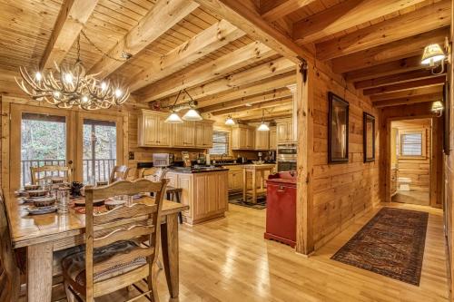 a dining room and kitchen in a log cabin at Bear Hug Cabin Gatlinburg Convenient to Everything! in Gatlinburg
