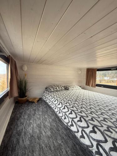 a bedroom with a large bed in a room at Domek w górach Tiny House Forest Jacuzzi/widoki in Lipnica Wielka