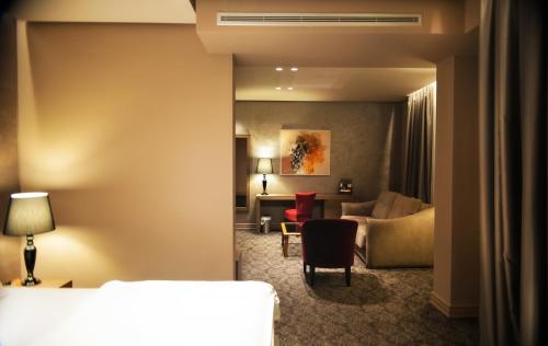 a hotel room with a bedroom and a living room at Mondial Hotel in Tirana