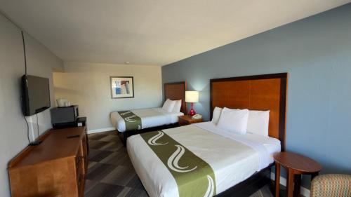 a hotel room with two beds and a television at Regency Inn in Chickasha