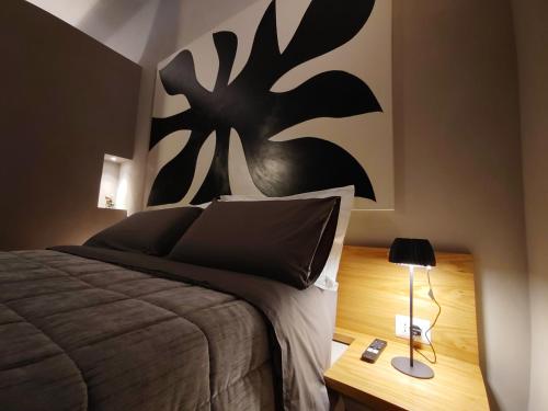 a bedroom with a bed with a black painting on the wall at RiDi Home 466- Suite in centro a 5 minuti dal mare in Porto SantʼElpidio