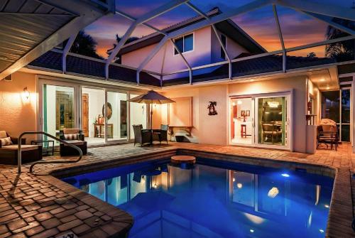 a swimming pool in the backyard of a house at Villa Hibiscus-Waterfront-Free Heated Pool-Dock-Bikes-Other Amenities in Punta Gorda