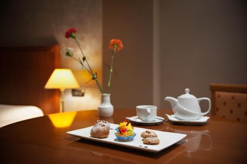 a table with two plates of food and a tea pot at Mondial Hotel in Tirana