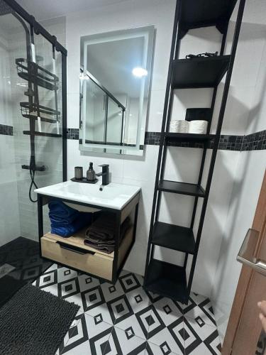 a bathroom with a mirror and a sink and a ladder at Appartement ALFONSO in Salou