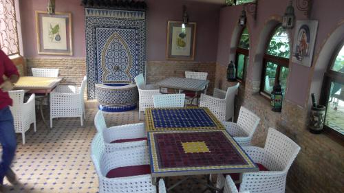 a restaurant with white chairs and tables in a room at Pasta Plaza in Asilah