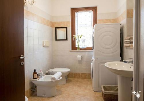 a white bathroom with a sink and a toilet at Casa Maribel in Salionze