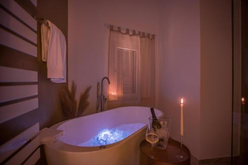 a bath tub with a candle in a bathroom at Tosco Suite "Ecclesia" in Sasso dʼOmbrone