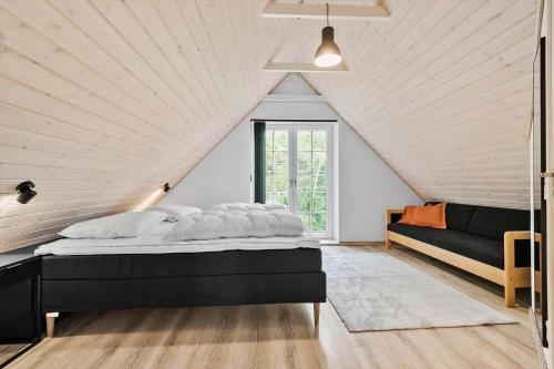 a bedroom with a black bed and a couch at BV262-Billum-Ho-Bugt-Vej-6 in Billum