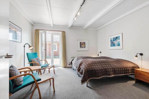 a bedroom with a bed and a table and chairs at BV255-Blavand-Vesterhavsparken-39 in Blåvand