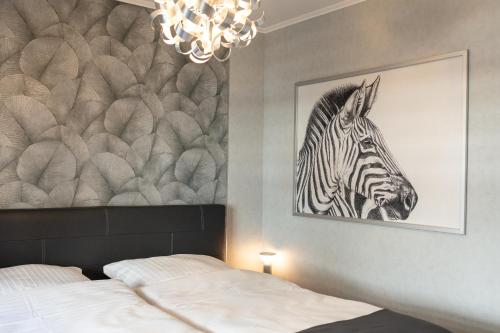 a bedroom with a picture of a zebra on the wall at Apartment MeerZeit in Büsum