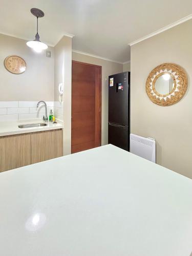 a kitchen with a sink and a black refrigerator at Departamento Pucón in Pucón