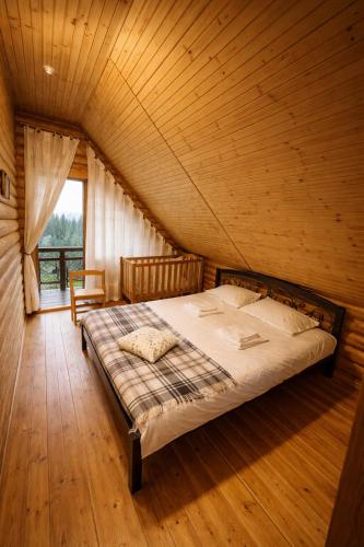 a bedroom with a bed in a wooden room at Cottage Smerekovyi in Skole