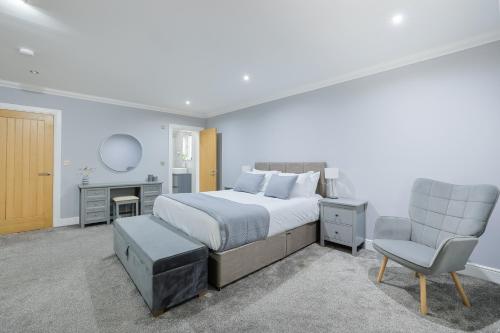 a bedroom with a bed and a chair and a desk at Connel House - Luxury self-catering 4-bedroom home in Connel