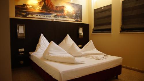 a bedroom with a bed with white pillows on it at Gersthofer Auszeit in Gersthofen