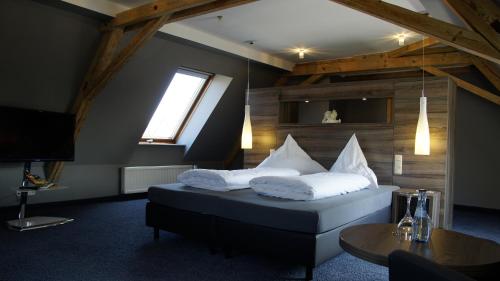 a bedroom with a bed with white pillows and a television at Gersthofer Auszeit in Gersthofen