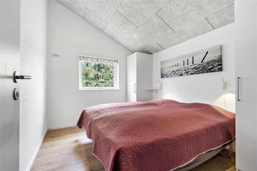 a bedroom with a bed in a white room at BV155-Blavand-Gronnevaenget-1-D in Blåvand