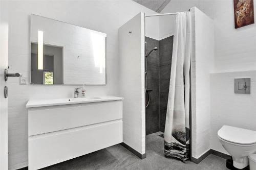 a bathroom with a toilet and a sink and a shower at BV155-Blavand-Gronnevaenget-1-D in Blåvand