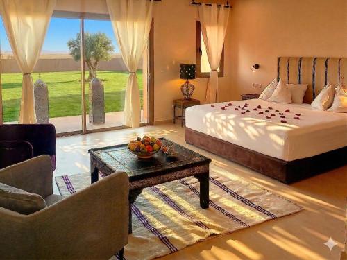 a bedroom with a bed and a table with a bowl of fruit at Bab Sma in Oumnas