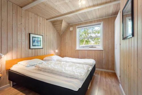 a bed in a small room with a window at BV319-Blavand-Savmollen-14 in Blåvand