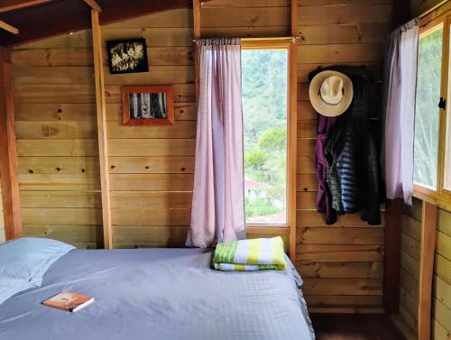 a bedroom with a bed in a log cabin at Refugio Munay in Florián