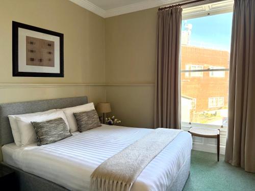 a bedroom with a bed and a large window at Berkeley House in Kilkenny