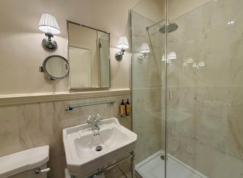 a bathroom with a sink and a shower with a mirror at Berkeley House in Kilkenny