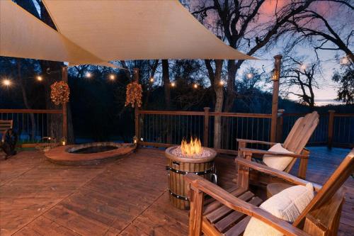 a patio with two chairs and a fire pit at Halfling House w/hot tub/firepit/more! in Coarsegold