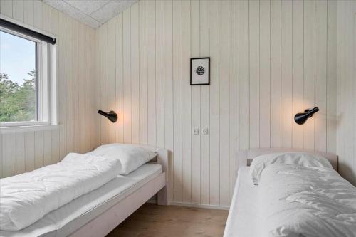 a bedroom with two beds and a window at BV208-Blavand-Strandparken-16 in Blåvand