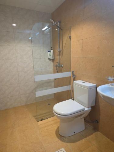 a bathroom with a toilet and a shower and a sink at Muscat Beach Hostel in Muscat