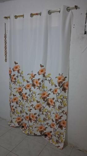 a shower curtain with flowers on it in a bathroom at EASTDEE by Jaya in Lidlidda