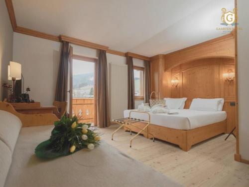 a bedroom with a bed and a large window at Gaarten Hotel Benessere Spa by Kleos Group Collection in Gallio
