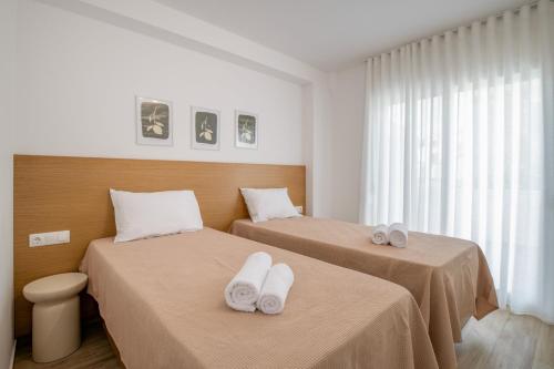 two beds in a hotel room with towels on them at Casa Angelica in Patitiri