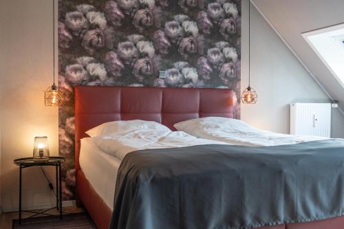 a bedroom with a bed with a painting on the wall at Encore Seaside in Büsum