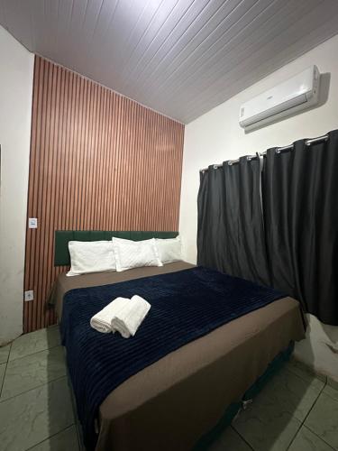 a bedroom with a bed with two towels on it at Apto garagem incluso in Marabá
