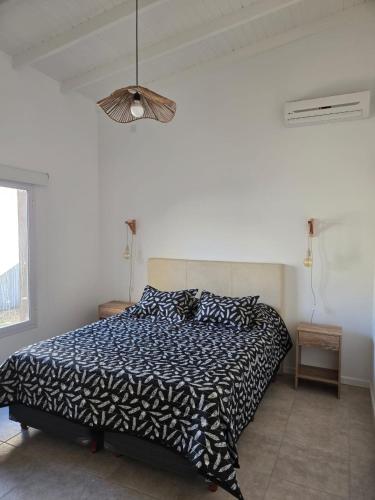 a bedroom with a bed with a black and white comforter at Casita Cómoda y Acogedora in Trenque Lauquen